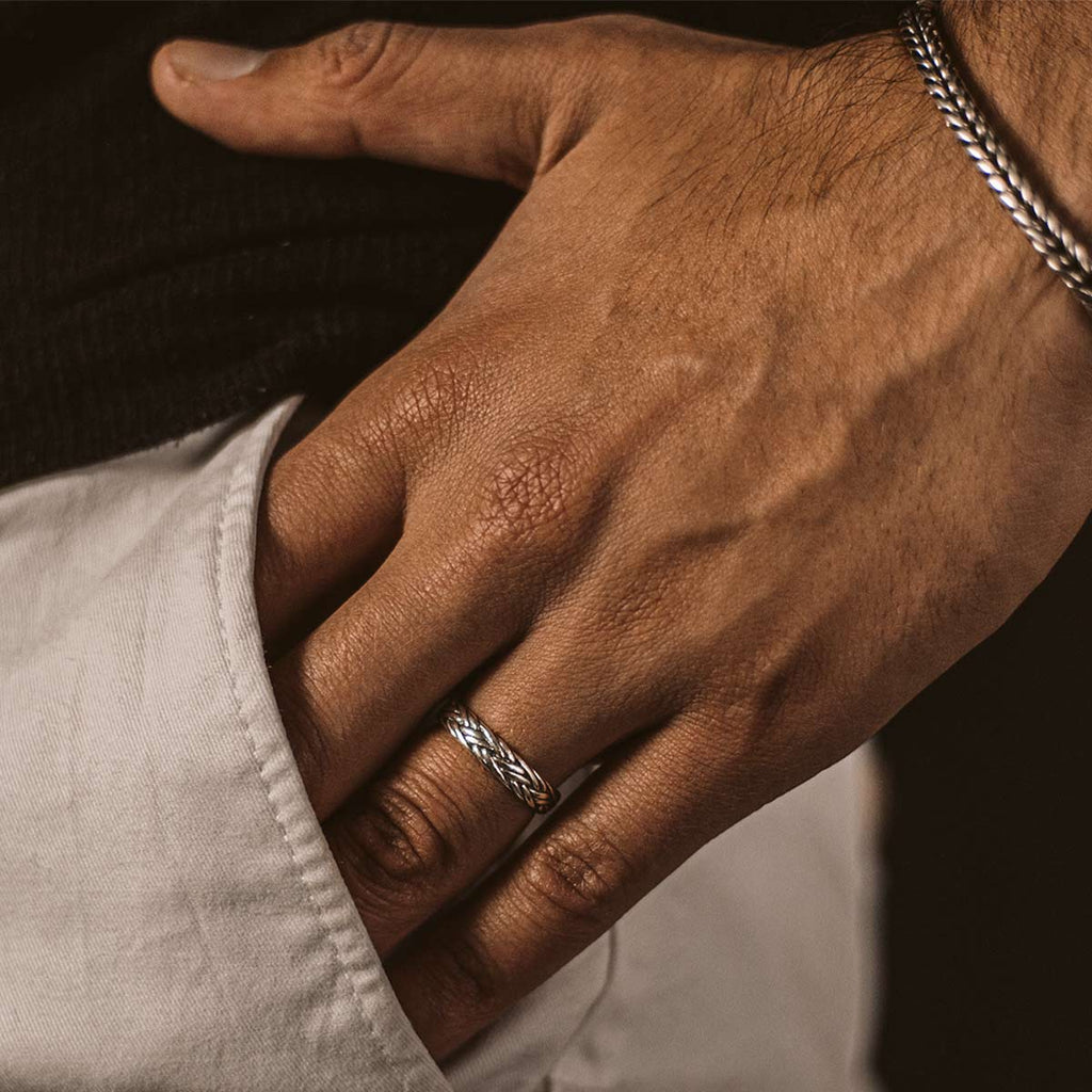 Die Hand eines Mannes zeigt stolz den Latif - Thin Sterling Silver Braided Ring 5mm.