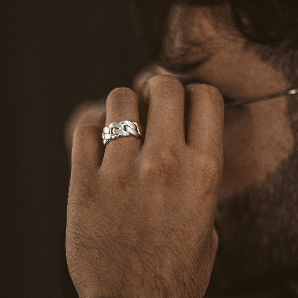 A man wearing a Rayen - Silver Cuban Link Ring 9mm on his finger.