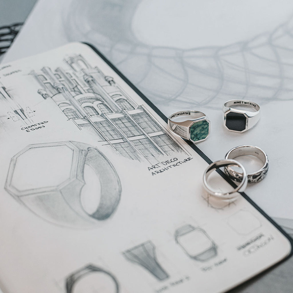 A sketch of a Naim - Black Onyx Signet Ring 13mm on top of a notebook.