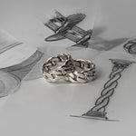 Ein Paar Rayen - Silber Cuban Link Ring 9mm auf der Spitze einer Zeichnung.