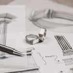 An elegant Imad - Sterling Silver Pillar Signet Ring 8mm and a pen resting on a piece of paper.