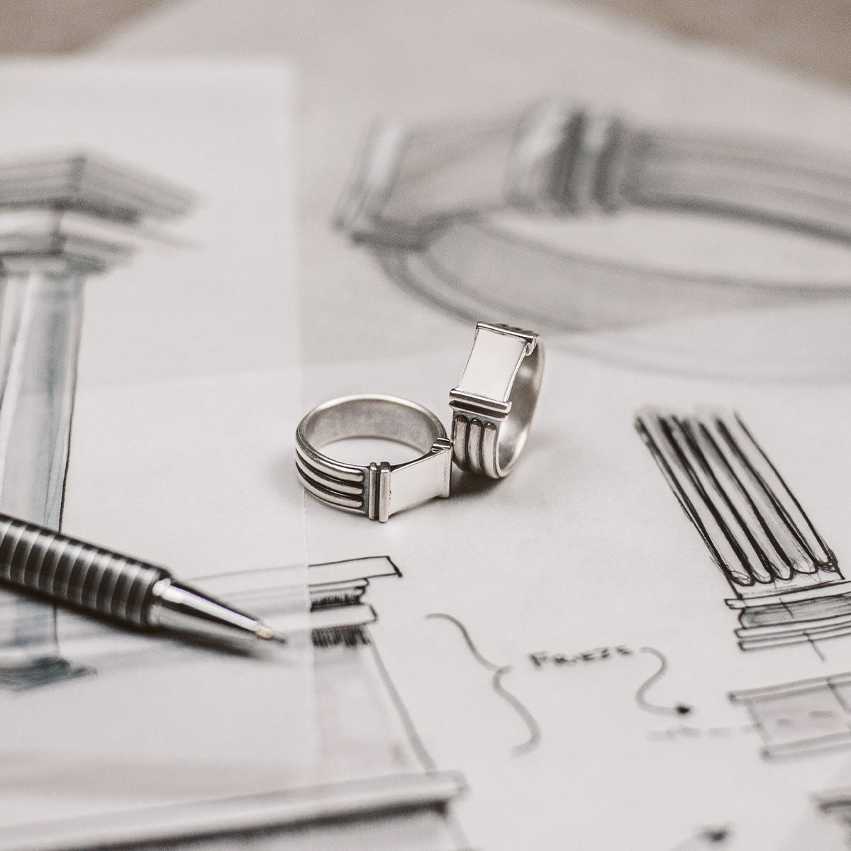 An elegant Imad - Sterling Silver Pillar Signet Ring 8mm and a pen resting on a piece of paper.