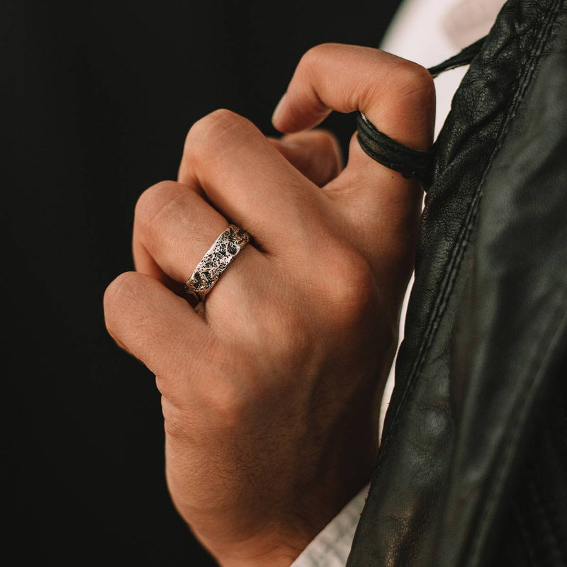 A man wearing a black leather jacket and a Tarif unique sterling silver mens ring by Ninetwofive.