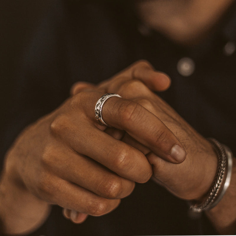 A man wearing a Tarif mens ring, silver bracelet and a cuff by Ninetwofive.