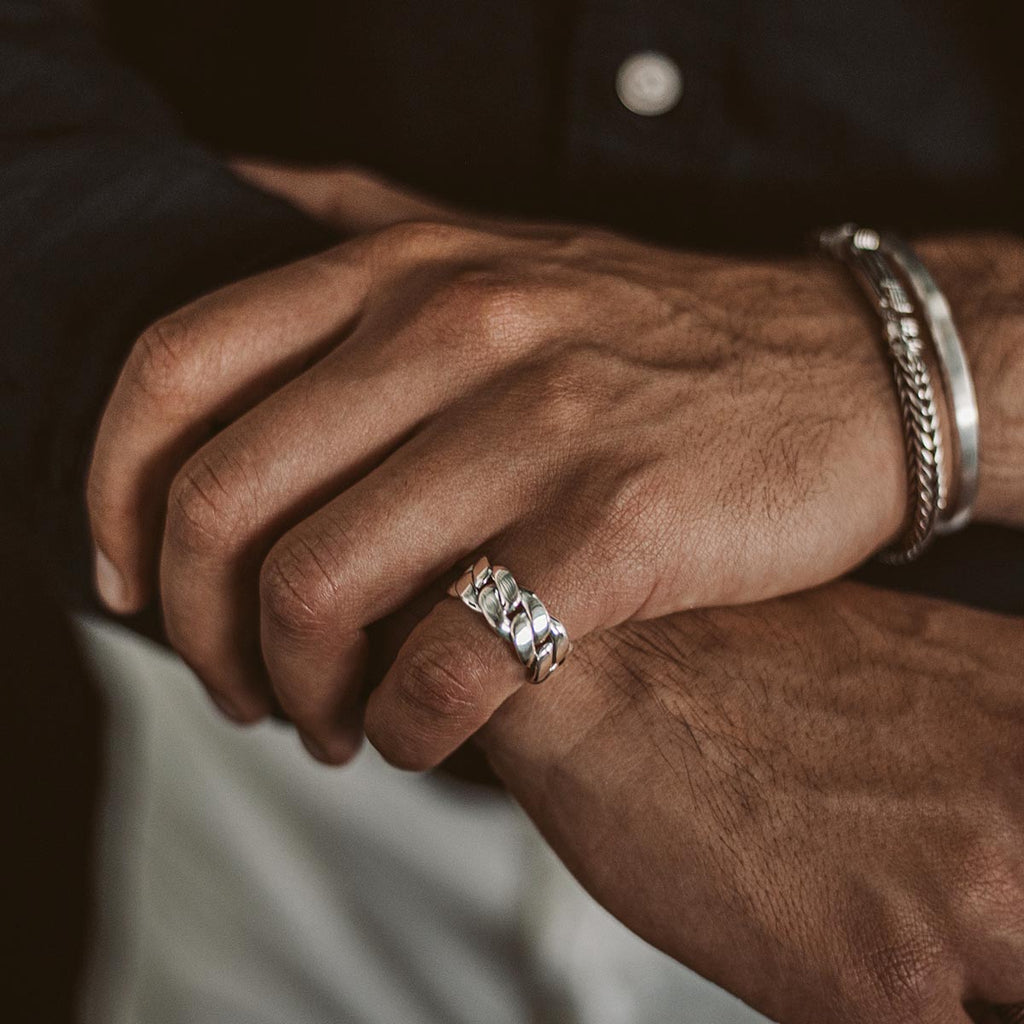 A man wearing the Rayen - Silver Cuban Link Ring 9mm on his hand.