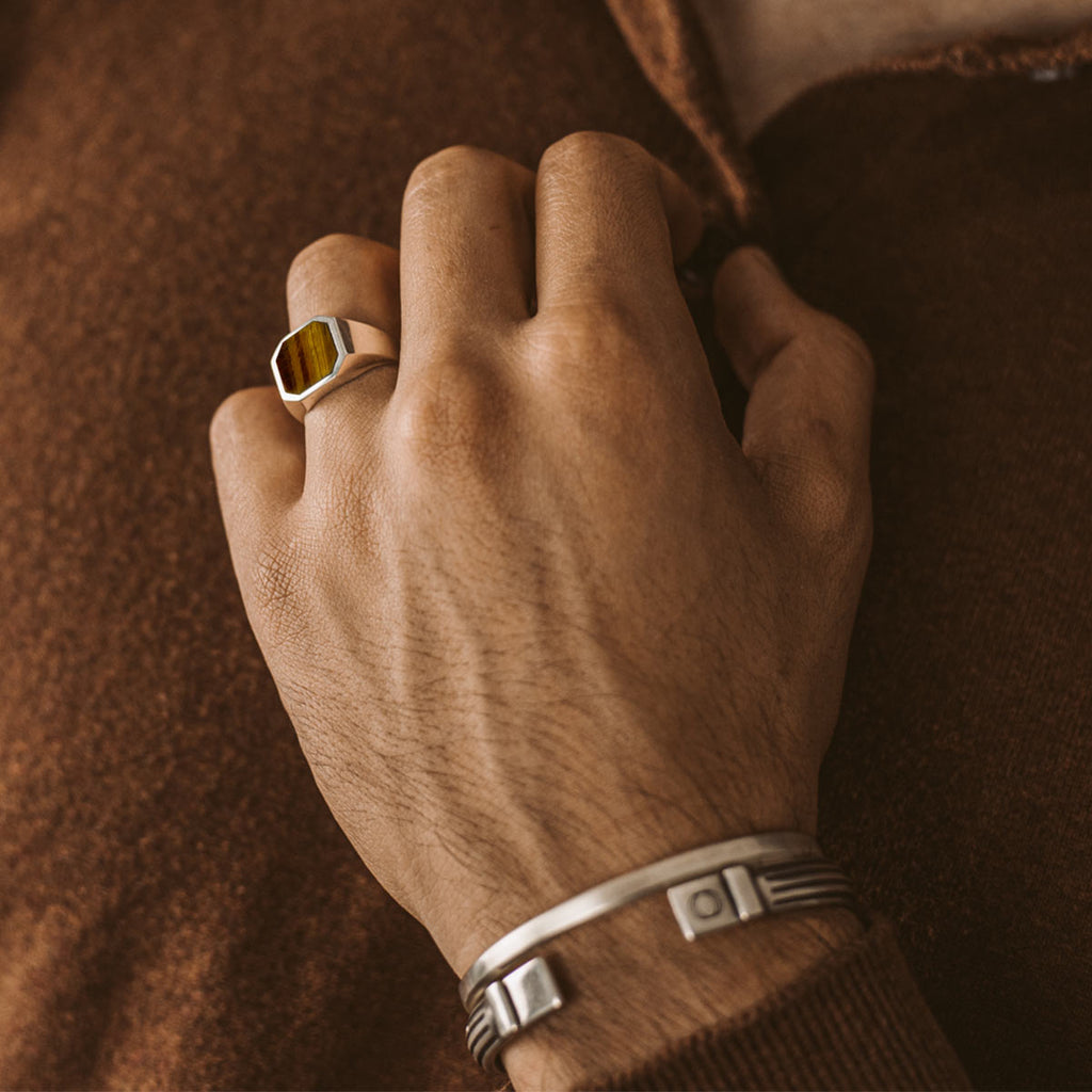 Een man draagt een Alem - Tijgeroogsteen Zegel Ring 13mm.