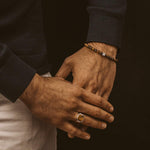 A man adorned with an Alnamr - Tiger Eye Beaded Bracelet 6mm ring and bracelet.