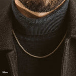 A close up of a handmade bearded man wearing an Anis - Sterling Silver Wheat Chain Necklace 3mm.