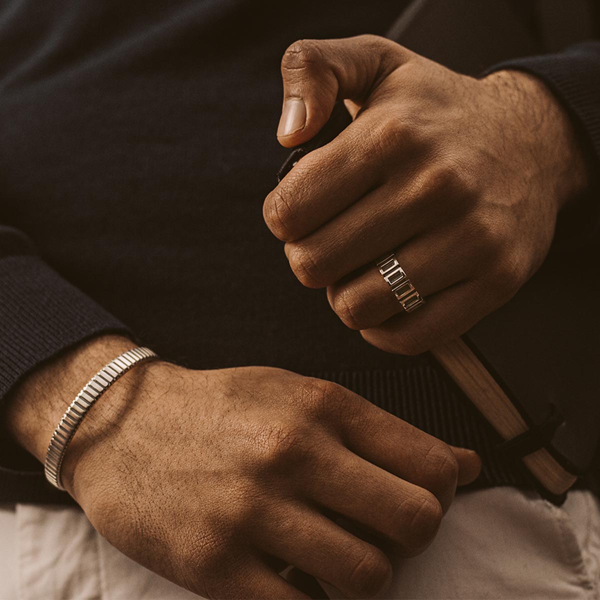 Ein Mann trägt einen Ring von Kenan and Yardan - set und ein handgefertigtes Buch.