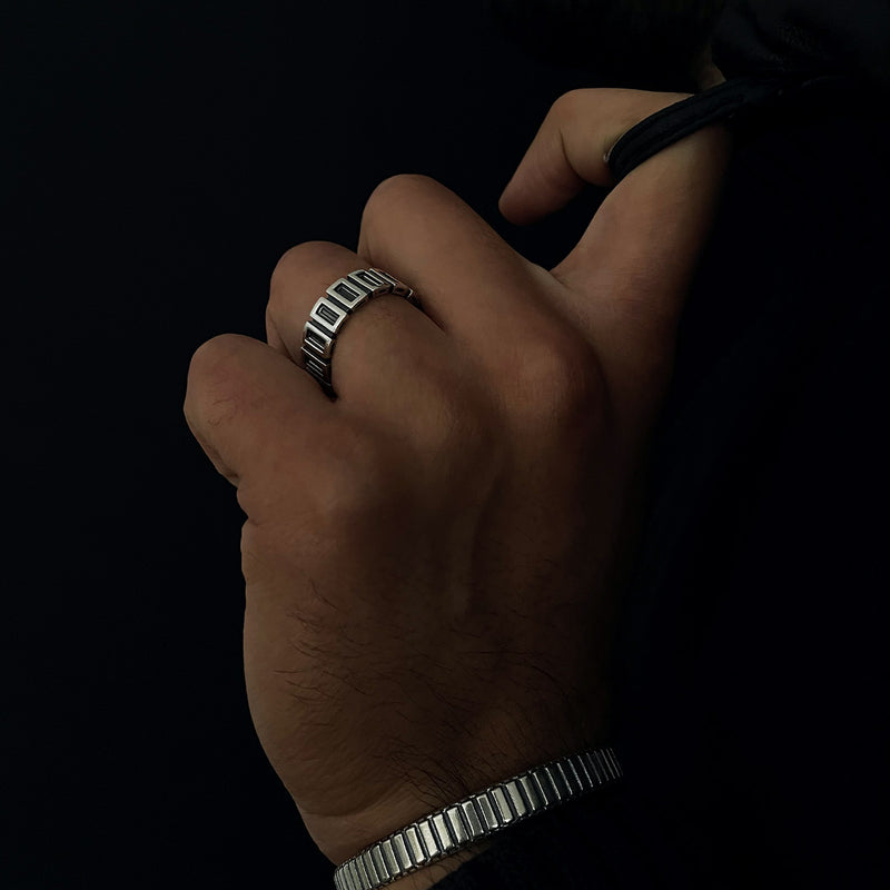 Een man draagt een Yardan geoxideerde sterling zilveren heren ring tegen een zwarte achtergrond.
