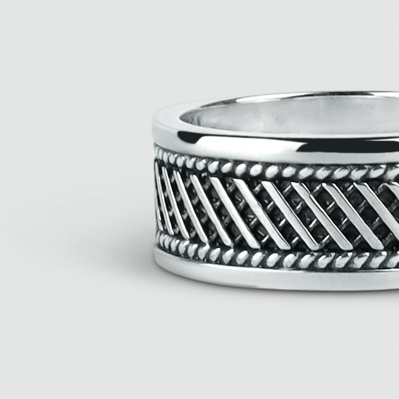 Close up angle view of Kaliq oxidised sterling silver ring with a braided design by Ninetwofive.