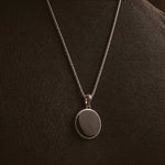 A man is wearing a Safar - Sterling Silver Onyx Compass Pendant necklace.