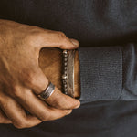 A man wearing a Kaliq - Adjustable Onyx Black Beaded Bracelet in Silver 6mm on his wrist.
