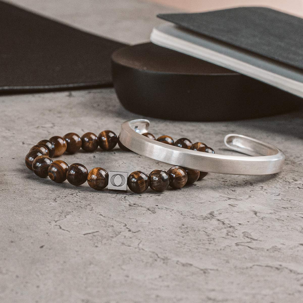 A pair of tiger eye bracelets on a desk.