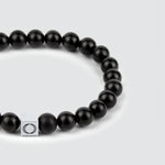 An Aswad - Matt Black Beaded Bracelet 8mm with a silver clasp, showcasing the mesmerizing beauty of the onyx stone.